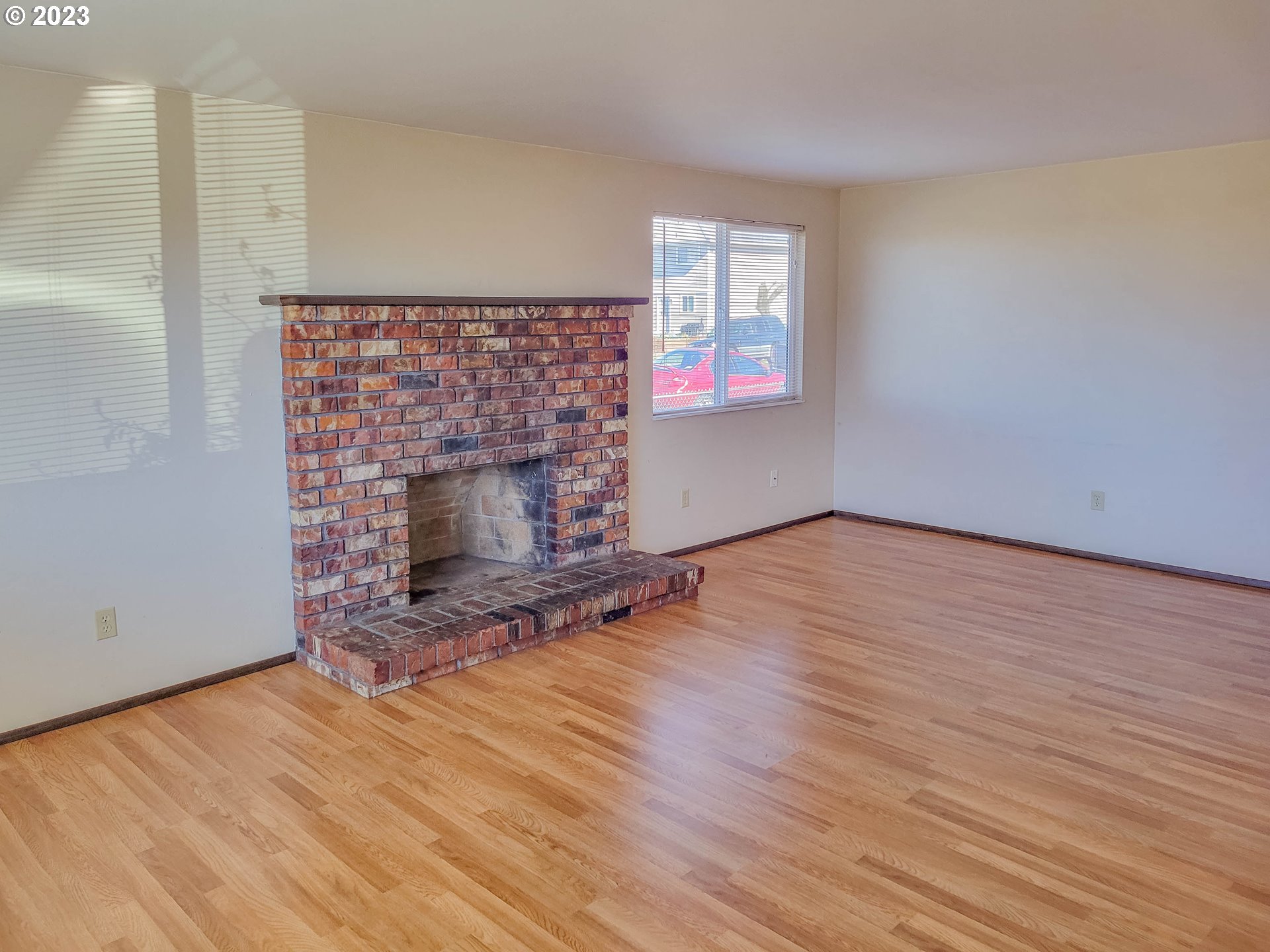 215 South 10th Street Lebanon, OR 97355 - Photo 2 of 9 an empty room with wooden floor and fireplace