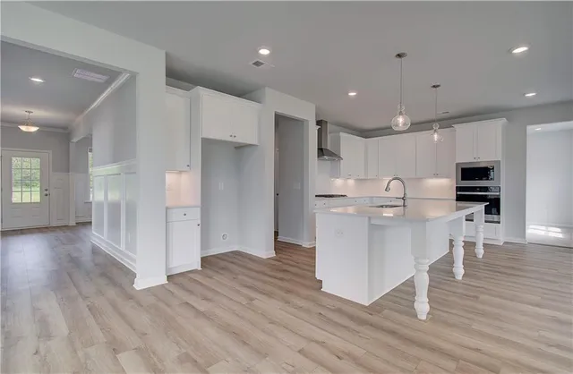 a kitchen with stainless steel appliances kitchen island granite countertop a refrigerator and a stove top oven