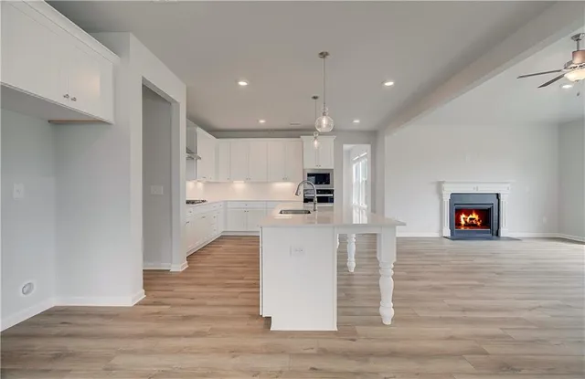 a open kitchen with white cabinets and stainless steel appliances