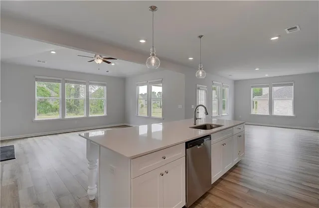 a large kitchen with granite countertop a sink and dishwasher with wooden floor