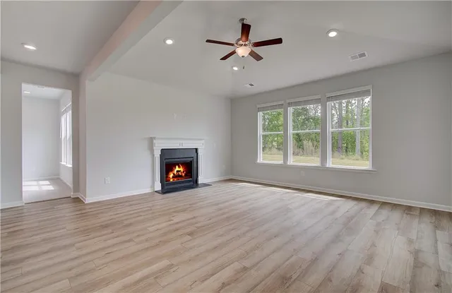 a view of an empty room with a window and fireplace