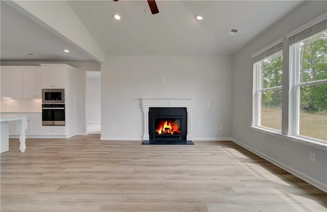 a view of an empty room with a window and fire place