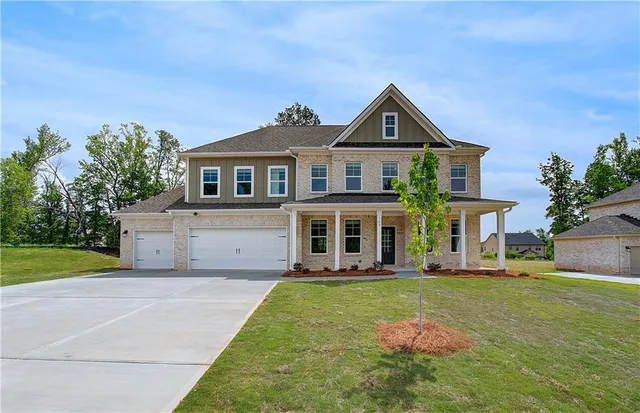 a front view of a house with a yard and garage