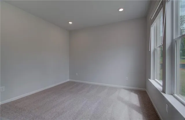 a view of hallway with window and wooden floor