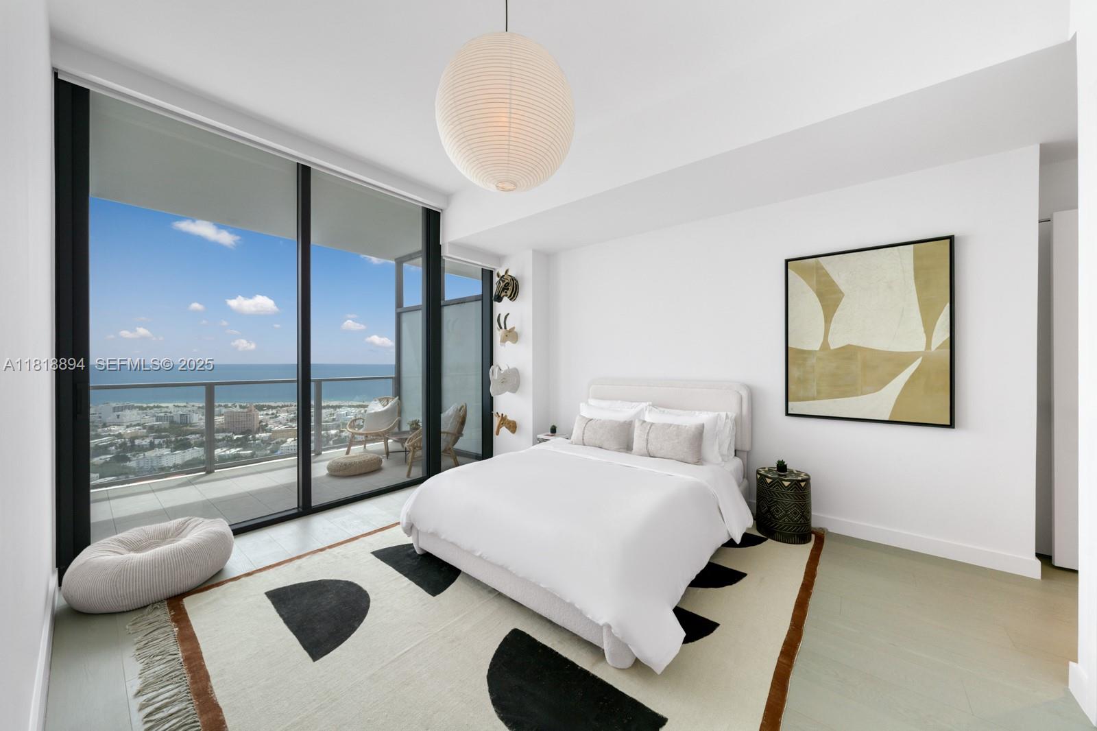 500 Alton Road, Unit 4004 Miami Beach, FL 33139 - Photo 14 of 26 a bedroom with a bed and glass door