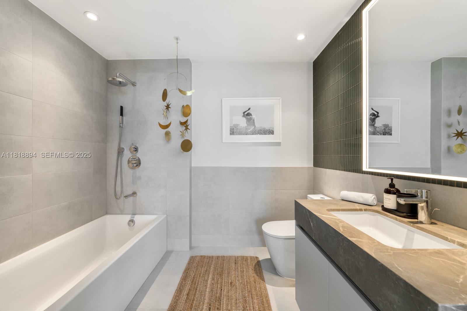 500 Alton Road, Unit 4004 Miami Beach, FL 33139 - Photo 16 of 26 a bathroom with a granite countertop sink a toilet a bathtub and shower