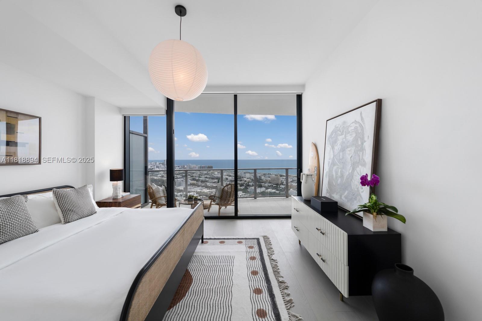 500 Alton Road, Unit 4004 Miami Beach, FL 33139 - Photo 9 of 26 a spacious bedroom with a large bed and a chandelier