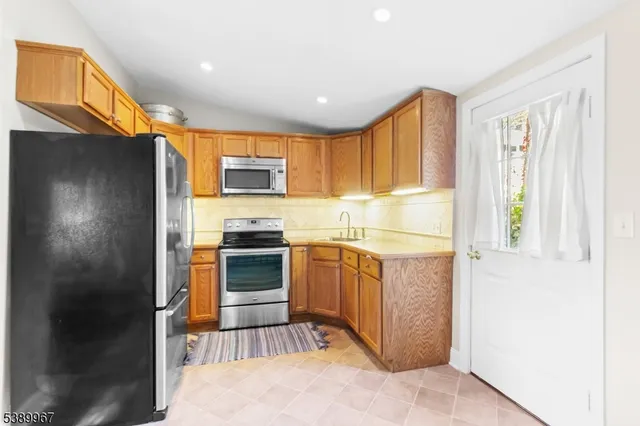a kitchen with stainless steel appliances granite countertop a refrigerator and a sink
