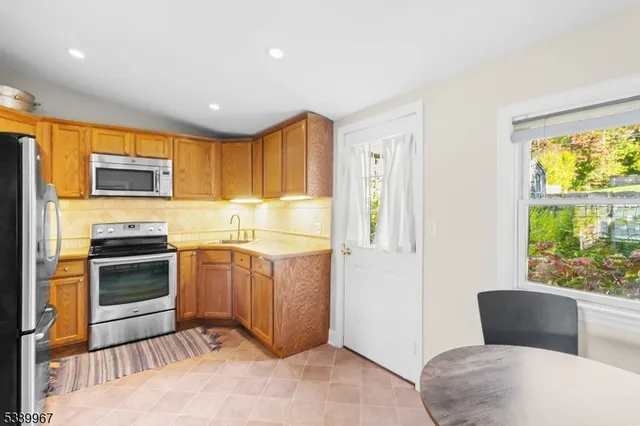 a kitchen with stainless steel appliances granite countertop a stove a sink and a refrigerator