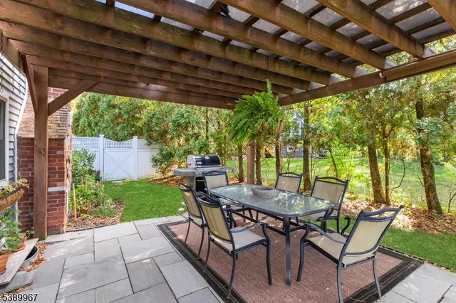 a view of a patio with a table and chairs under an umbrella