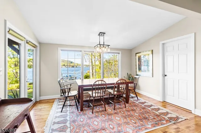 a dining room with wooden floor and a rug