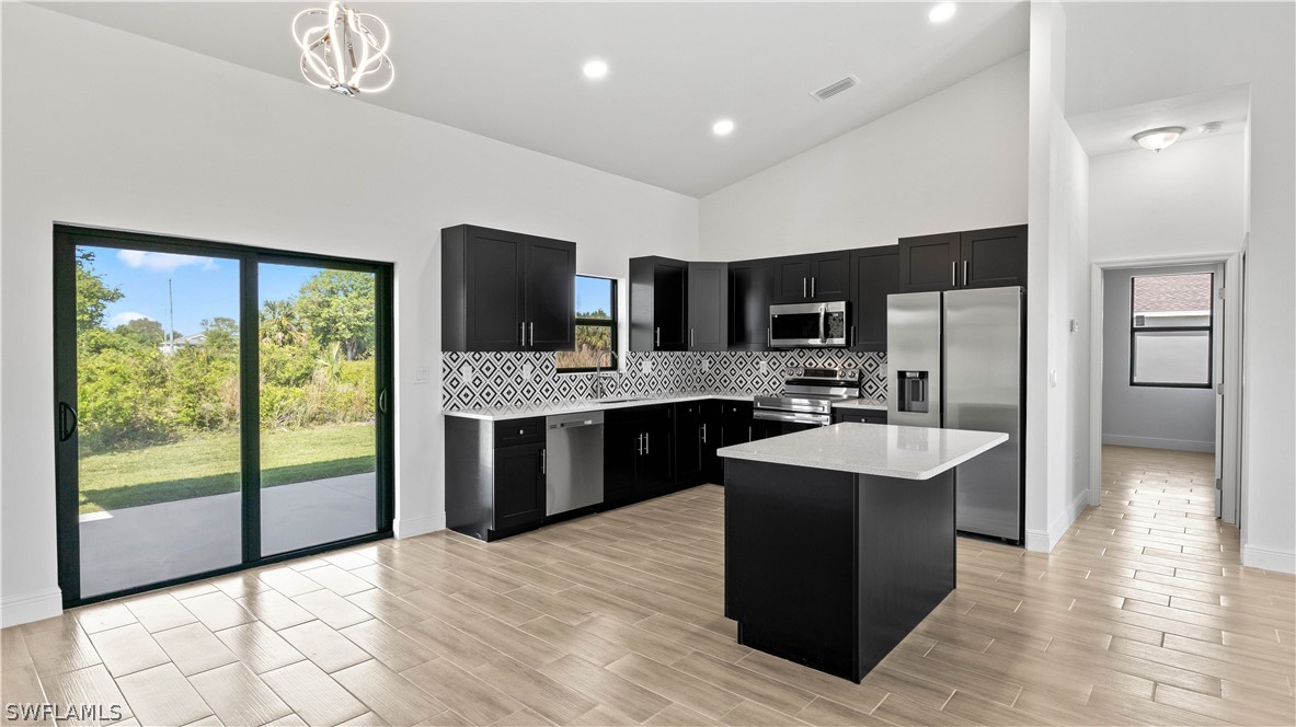 a large kitchen with stainless steel appliances granite countertop a sink counter space cabinets and a large window