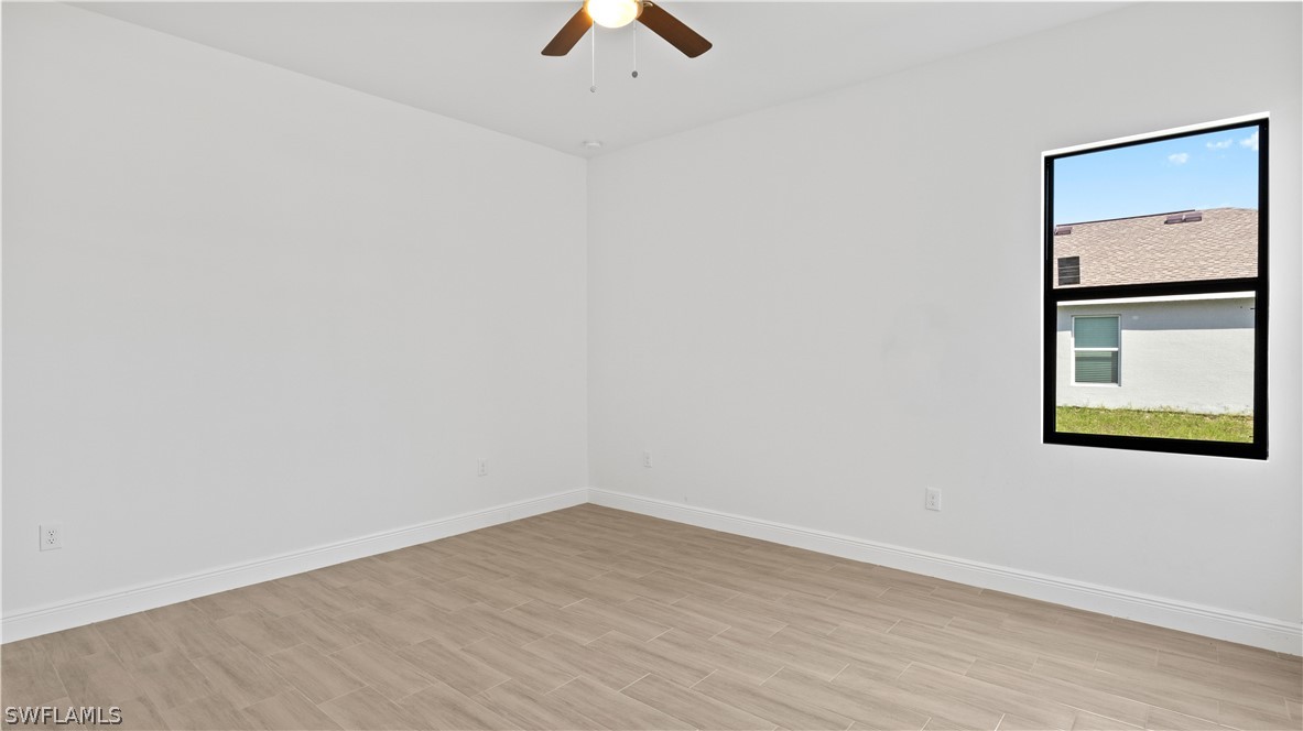 422 Progress Avenue Lehigh Acres, FL 33974 - Photo 13 of 35 an empty room with a window and a ceiling fan