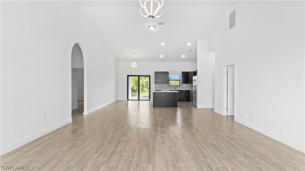 422 Progress Avenue Lehigh Acres, FL 33974 - Photo 2 of 35 a view of a kitchen and dining room with wooden floor