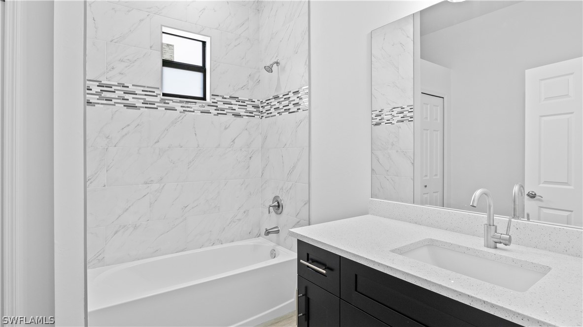 422 Progress Avenue Lehigh Acres, FL 33974 - Photo 23 of 35 a bathroom with a tub sink and mirror