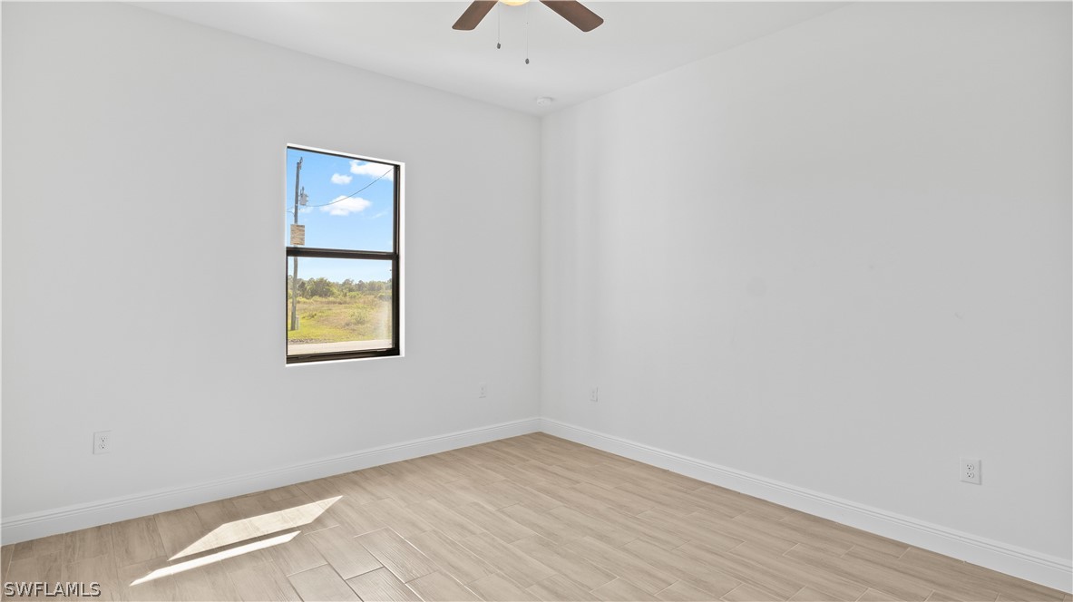 422 Progress Avenue Lehigh Acres, FL 33974 - Photo 24 of 35 an empty room with a window and a ceiling fan