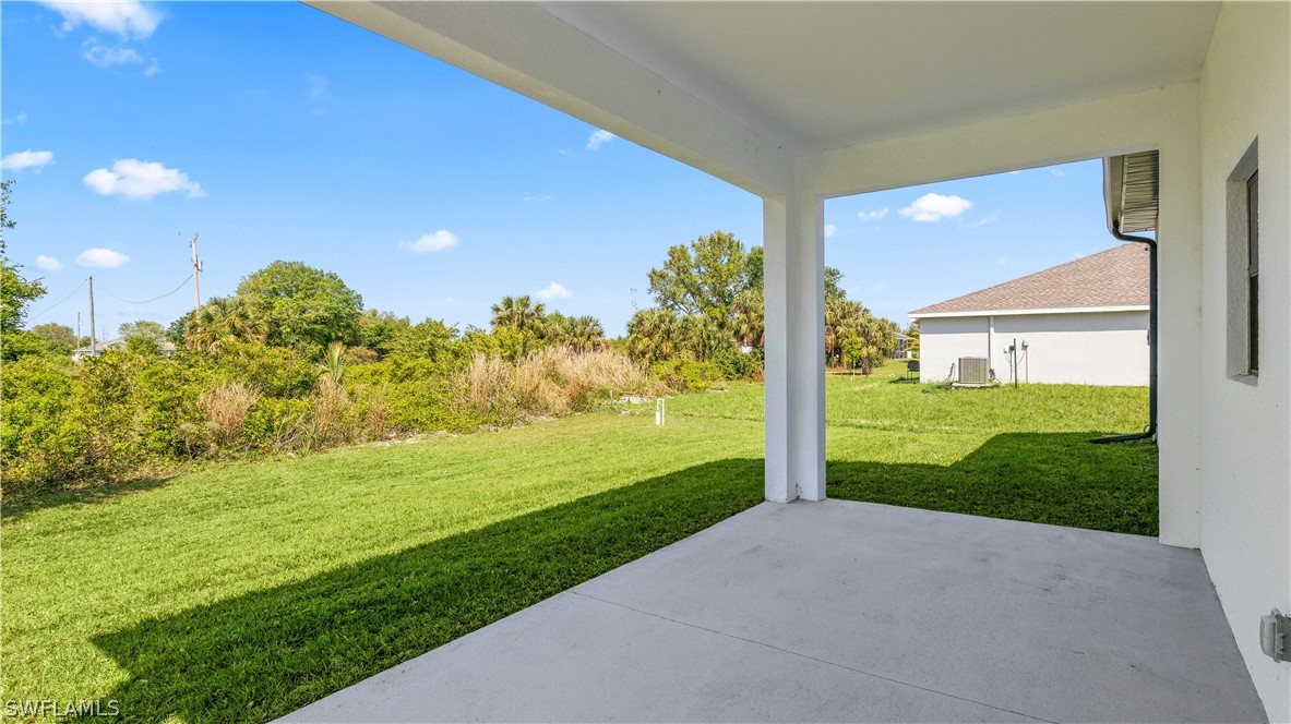 422 Progress Avenue Lehigh Acres, FL 33974 - Photo 30 of 35 a view of a big room with floor to ceiling windows and yard