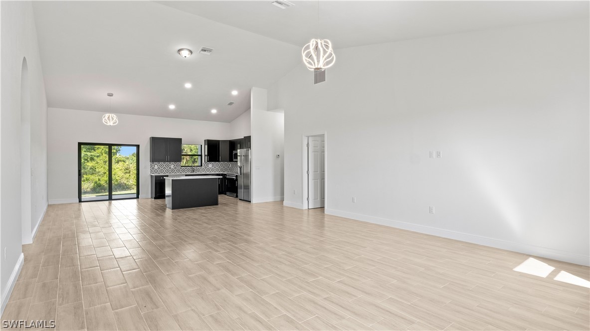 422 Progress Avenue Lehigh Acres, FL 33974 - Photo 3 of 35 a view of kitchen and hall with wooden floor