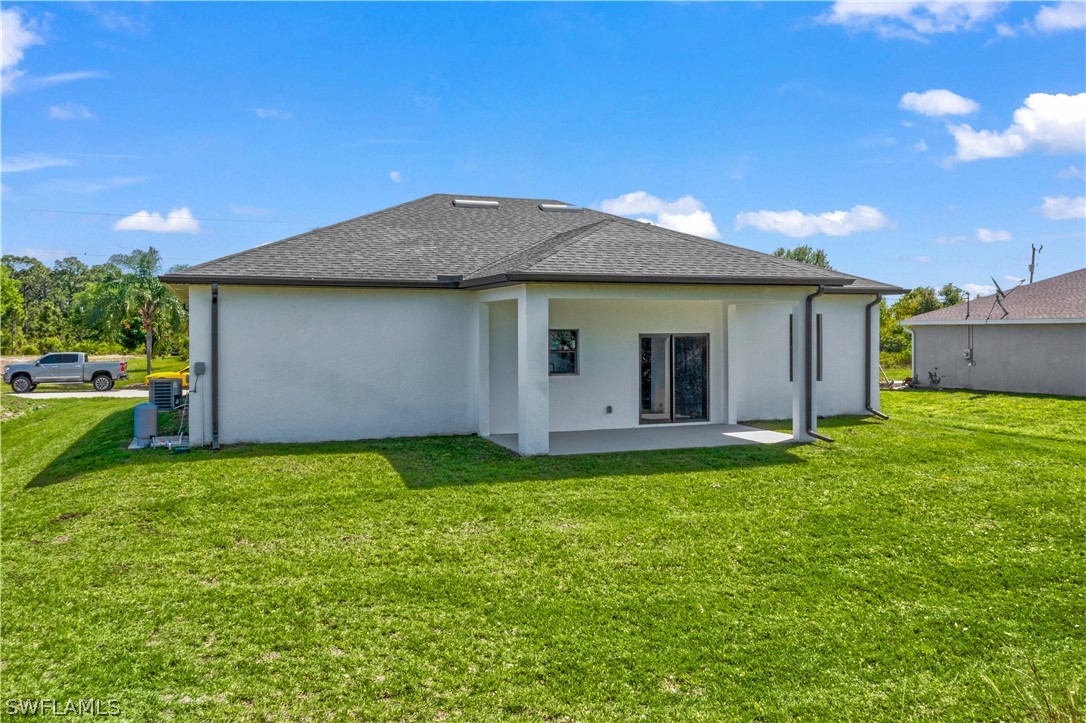 422 Progress Avenue Lehigh Acres, FL 33974 - Photo 31 of 35 a backyard of a house with table and chairs