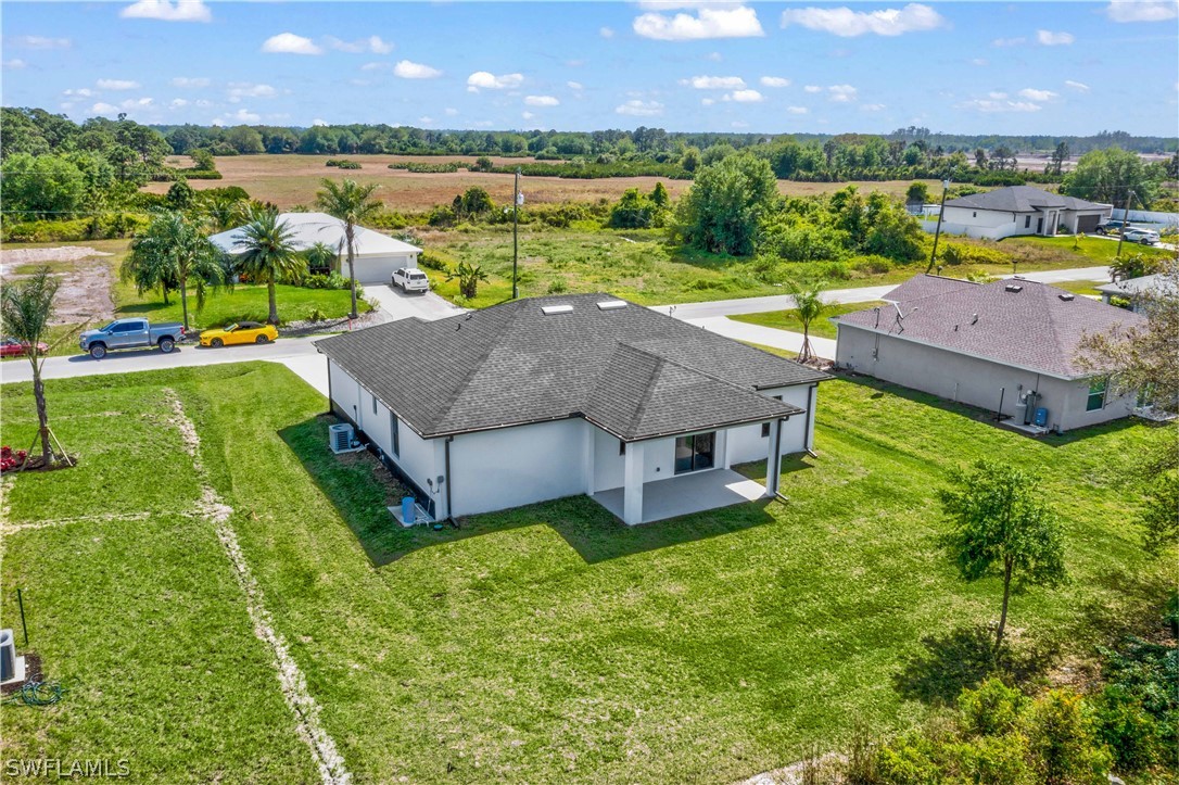 422 Progress Avenue Lehigh Acres, FL 33974 - Photo 33 of 35 an aerial view of a house with a garden and lake view