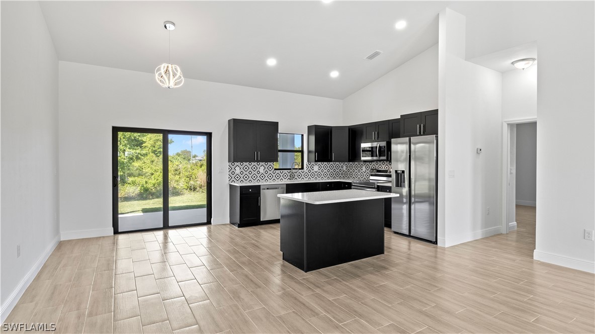 422 Progress Avenue Lehigh Acres, FL 33974 - Photo 5 of 35 a large kitchen with stainless steel appliances granite countertop a stove a sink and a refrigerator