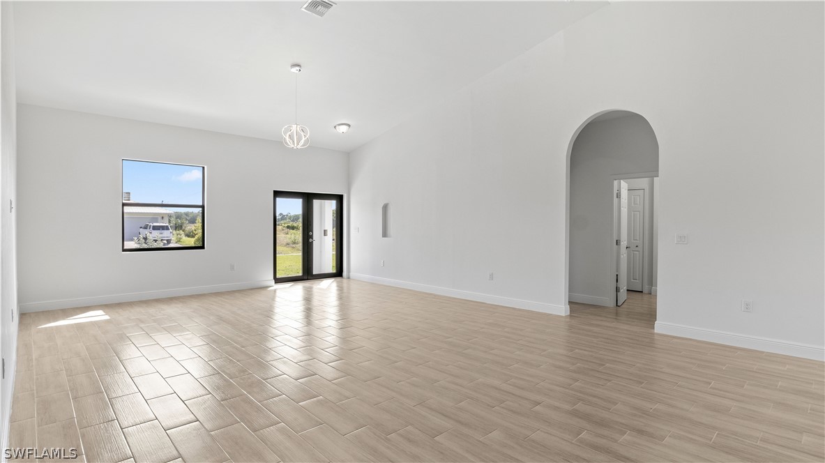 422 Progress Avenue Lehigh Acres, FL 33974 - Photo 9 of 35 a view of an empty room with window and wooden floor