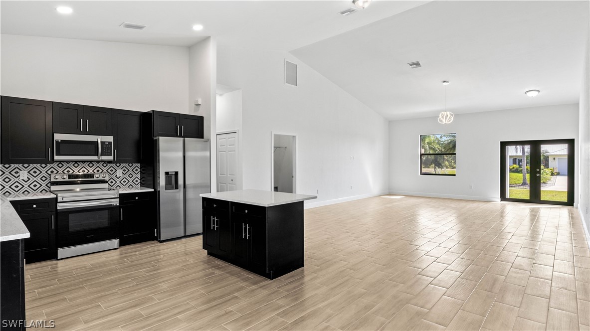 422 Progress Avenue Lehigh Acres, FL 33974 - Photo 10 of 35 a large kitchen with a stove and a refrigerator