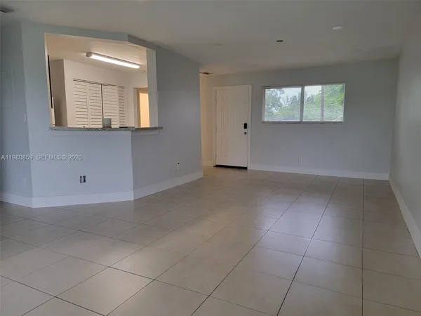 an empty room with floor to ceiling window and an outdoor view