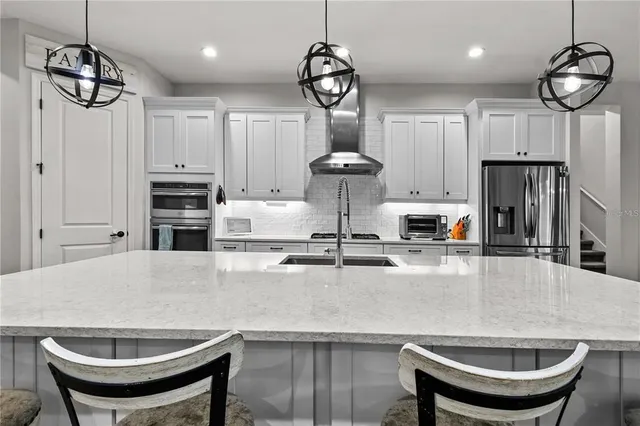 a dining room with furniture a chandelier and wooden floor