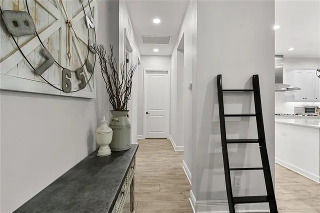 a view of a livingroom with wooden floor and a hallway