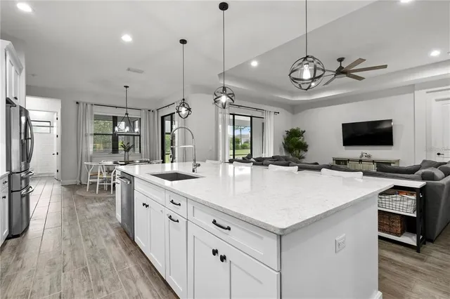 a living room with furniture and a view of kitchen