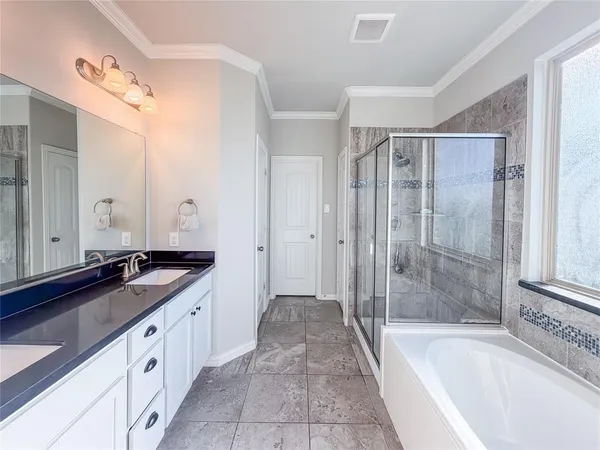 a spacious bathroom with a granite countertop tub sink a mirror a shower and vanity