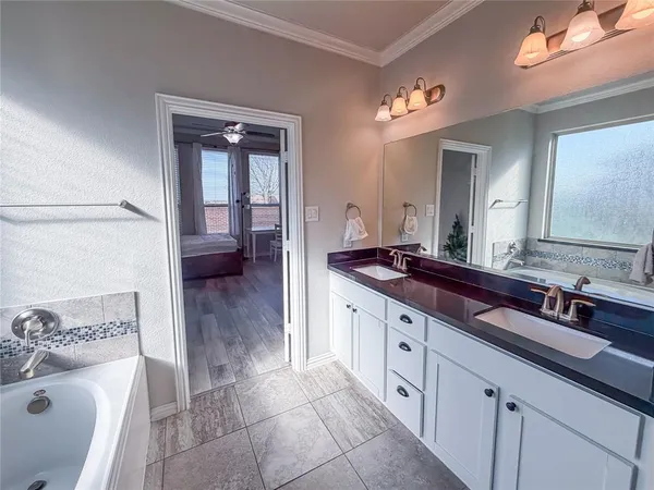 a spacious bathroom with a double vanity sink a mirror and a