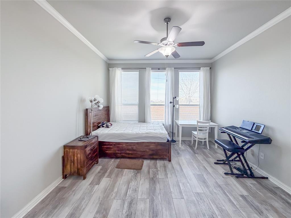 328 Callaghan Drive Fate, TX 75189 - Photo 15 of 37 a bedroom with a bed and a chandelier