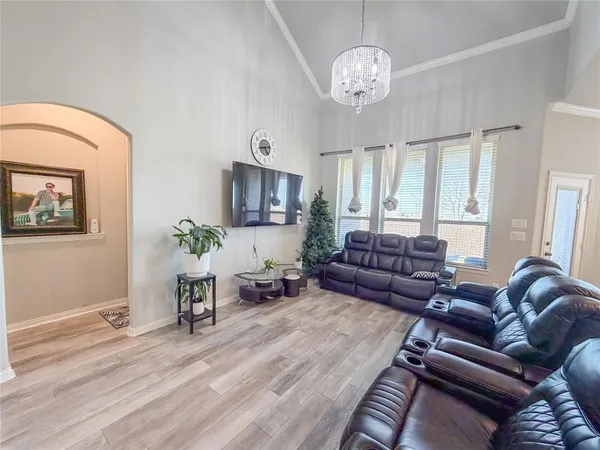 a living room with furniture a chandelier and a window
