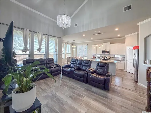 a living room with furniture kitchen and a chandelier