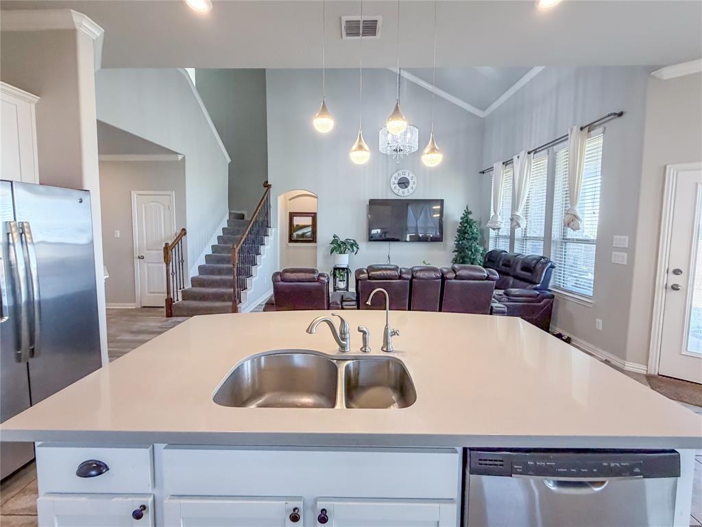328 Callaghan Drive Fate, TX 75189 - Photo 36 of 37 a kitchen with kitchen island granite countertop a sink a stove and refrigerator