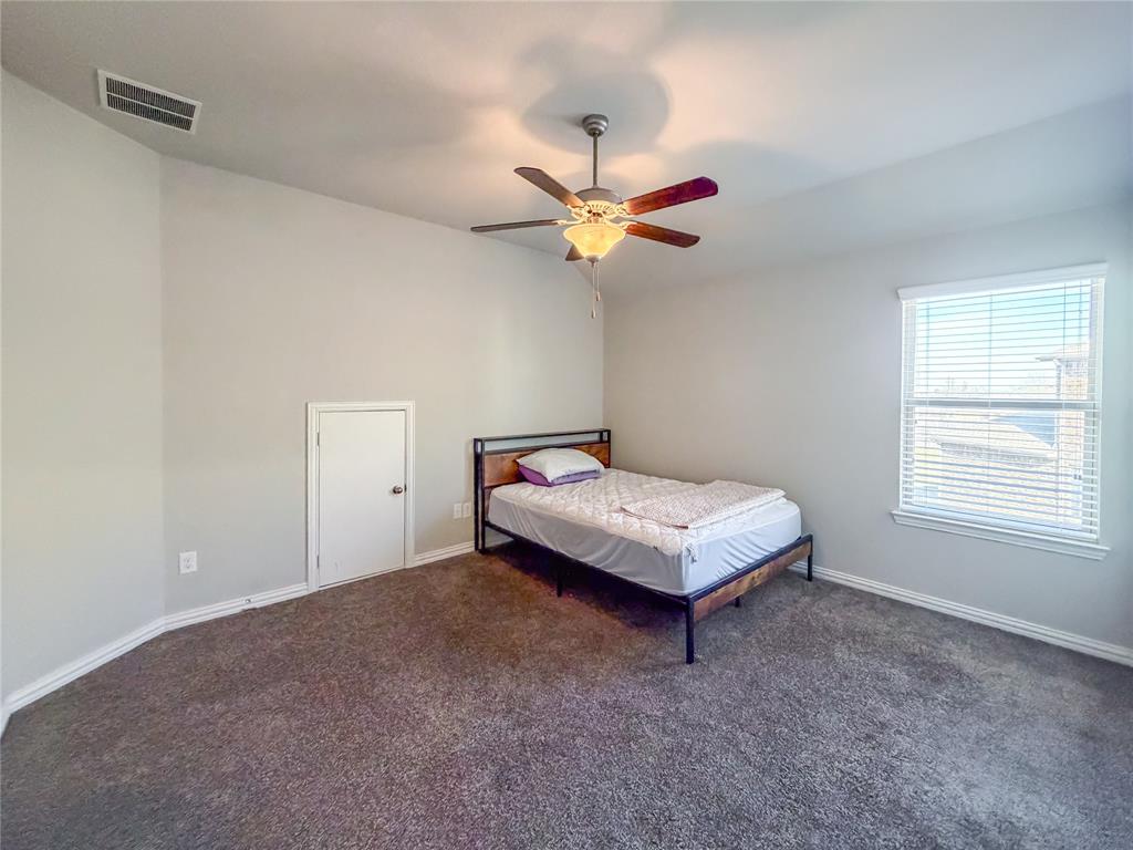 328 Callaghan Drive Fate, TX 75189 - Photo 24 of 37 a bedroom with a bed and a ceiling fan in it