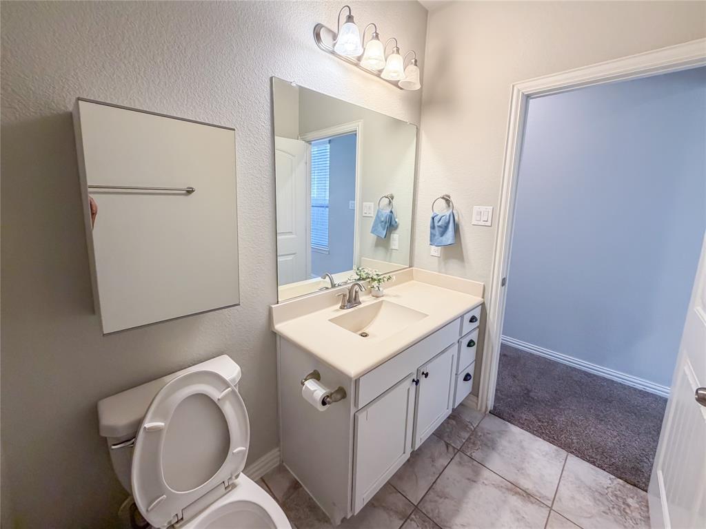 328 Callaghan Drive Fate, TX 75189 - Photo 28 of 37 a bathroom with a sink a toilet and mirror