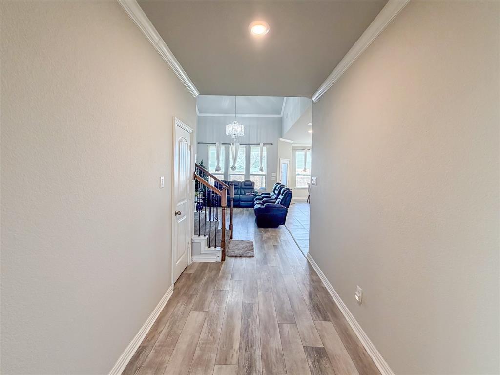 328 Callaghan Drive Fate, TX 75189 - Photo 10 of 37 a view of a hallway with wooden floor and a potted plant
