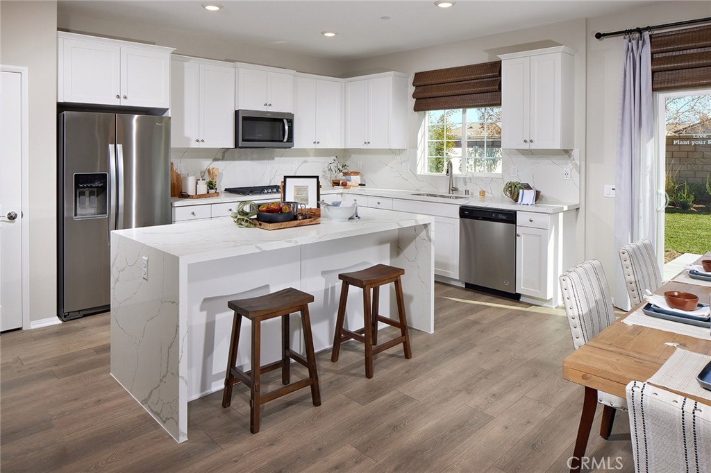 31099 Scrub Jay Road Winchester, CA 92596 - Photo 5 of 9 a kitchen with refrigerator cabinets and wooden floor