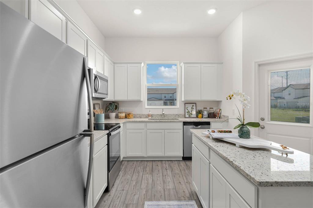 721 Poppy Lane Dundee, FL 33838 - Photo 12 of 26 a kitchen with a sink stove and refrigerator