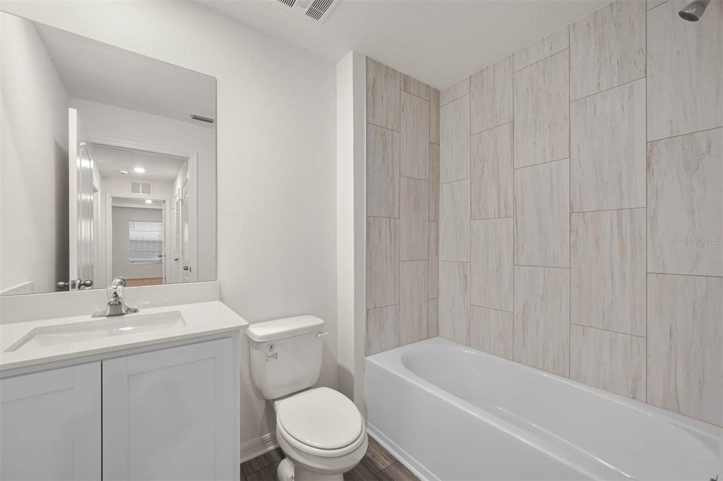 721 Poppy Lane Dundee, FL 33838 - Photo 23 of 26 a bathroom with a toilet a sink a mirror and vanity