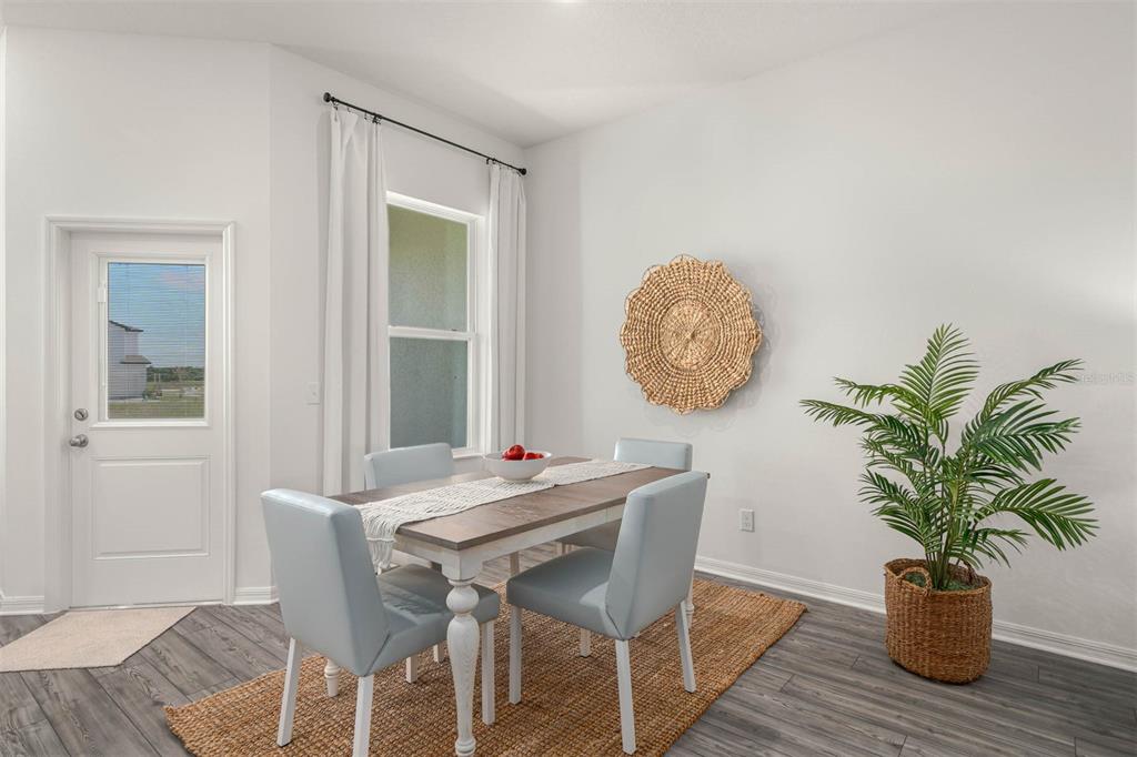 721 Poppy Lane Dundee, FL 33838 - Photo 9 of 26 a view of a dining room with furniture and wooden floor