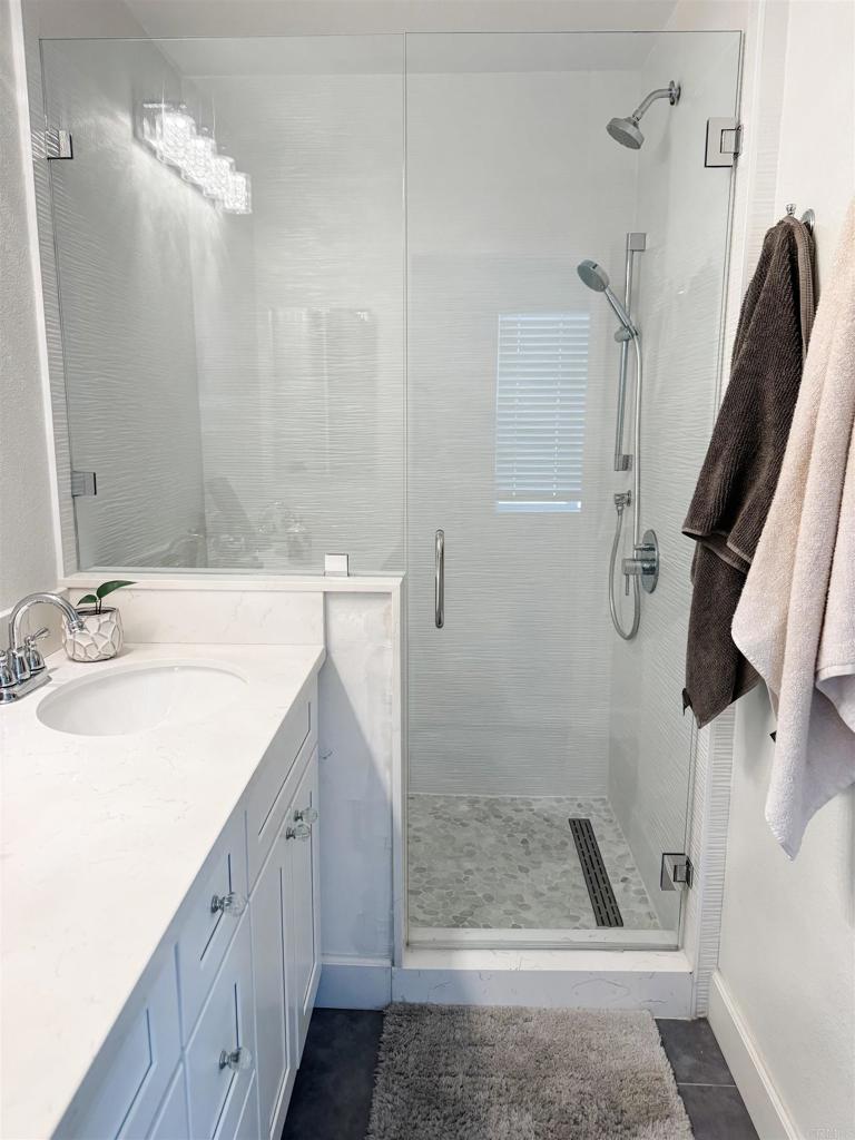 1461 Fieldbrook Street Chula Vista, CA 91913 - Photo 7 of 12 a bathroom with a sink a toilet a mirror and shower