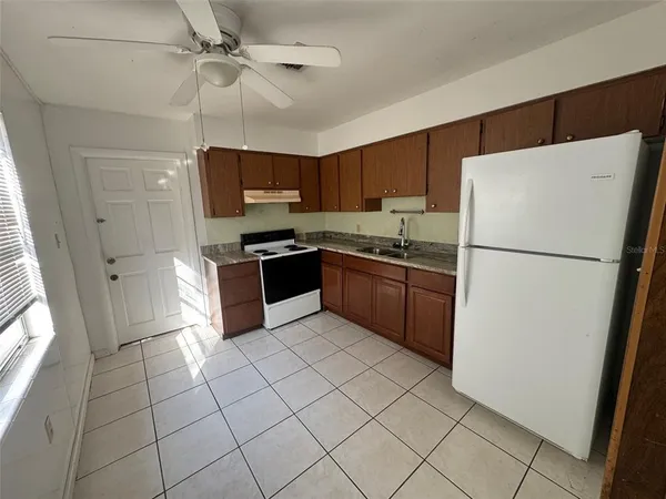a kitchen with stainless steel appliances granite countertop a refrigerator a sink a stove a microwave and island
