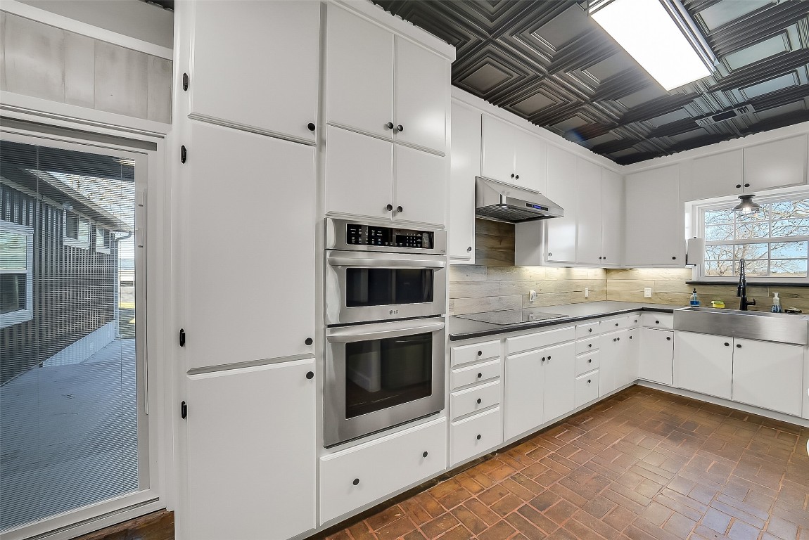 1005 Church Street Brenham, TX 77833 - Photo 13 of 44 a kitchen with granite countertop white cabinets and white appliances