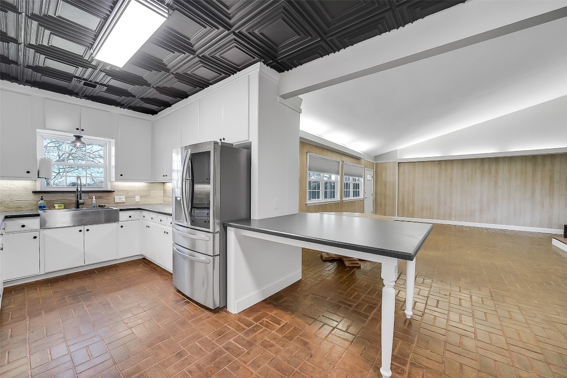 1005 Church Street Brenham, TX 77833 - Photo 14 of 44 a kitchen with stainless steel appliances kitchen island granite countertop a table chairs and a refrigerator