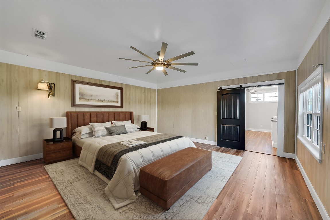 1005 Church Street Brenham, TX 77833 - Photo 19 of 44 a bedroom with a large bed and a ceiling fan
