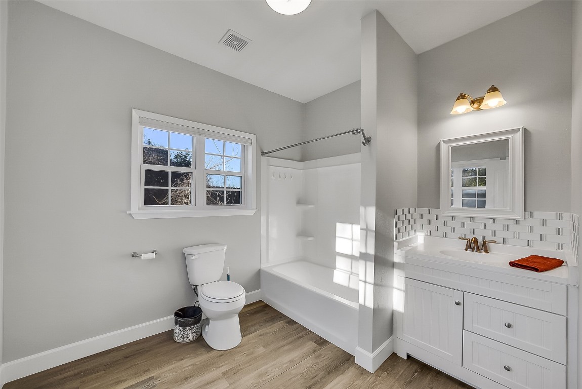 1005 Church Street Brenham, TX 77833 - Photo 30 of 44 a bathroom with a toilet sink and mirror